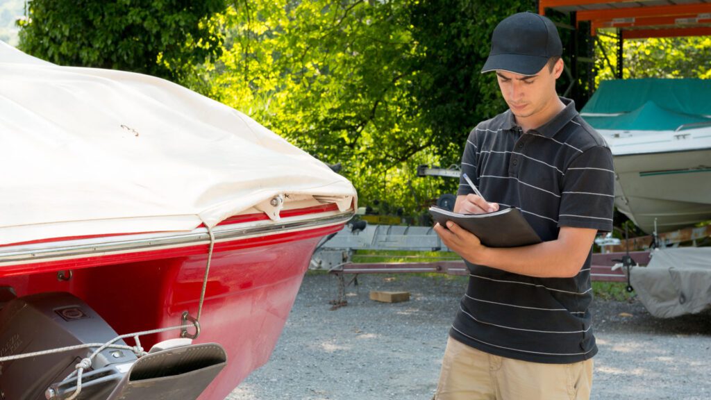 Man inspecting a red boat 
